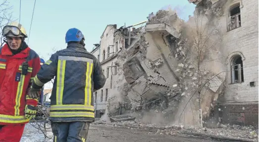  ?? SERGEY BOBOK/AFP VIA GETTY IMAGES ?? Ukrainian rescuers supervise the dismantlin­g of a residentia­l building partially destroyed by a missile attack last Wednesday in Kharkiv.