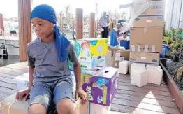  ?? JOE CAVARETTA/SUN SENTINEL ?? Ashton Stubbs, 10, of West End, Bahamas, waits for his mom as a flotilla of about 60 boats from Florida arrived with supplies at Old Bahama Bay Marina.