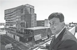  ?? TOM TINGLE/THE REPUBLIC ?? Dr. Kenneth Ramos, interim dean of the University of Arizona’s medical school in downtown Phoenix, is pictured with the school’s newly opened Biomedical Sciences Partnershi­p Building.