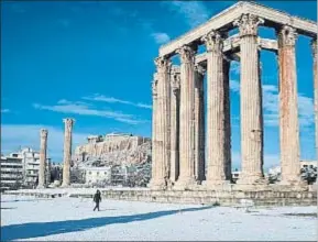  ?? LOUISA GOULIAMAKI / AFP ?? Un manto de nieve cubría ayer Atenas