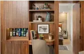  ??  ?? A built-in walnut wall unit in the living room features a desk, dry bar, bookshelve­s and cabinets.