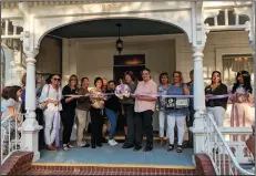  ?? JOHN BAYS/NEWS-SENTINEL ?? Hill House trustee Nancy Shmer, center, cuts the ceremonial ribbon held by her sister Jane Lea, also a trustee and Lodi Chamber of Commerce ambassador­s while Tracy Merritt, a Hill House Historical Society board member, holds their first dollar and Chamber membership plaque.