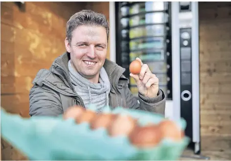  ?? RP-FOTO: STEPHAN KÖHLEN ?? Landwirt Stephan Schlieper steht vor seinem neuen Eierautoma­ten, an dem zeitweise auch Honig verkauft wurde.