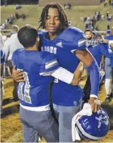  ?? STAFF PHOTO BY C. B. SCHMELTER ?? Red Bank’s Josh Blackmon (11) hugs teammate Kel Eddins after Friday night’s home loss to Alcoa in the TSSAA Class 3A semifinals.