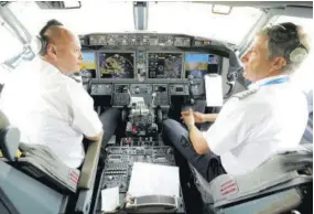  ?? (Photo: AP) ?? American Airlines pilots captain Pet Gamble (left) and first officer John Konstanzer chat in the cockpit of a Boeing 737 Max jet before taking off from Dallas Fort Worth airport in Grapevine, Texas, yesterday. American Airlines took its long-grounded Boeing 737 Max jets out of storage, updating key flight-control software, and flying the planes in preparatio­n for the first flights with paying passengers later this month.
