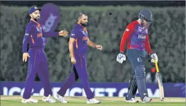  ?? AP ?? Mohammed Shami (C) after dismissing England's Jos Buttler during the World T20 warm-up match in Dubai on Monday.