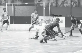  ?? ?? YMCA Old Fort’s Jael Gaskin attempts to evade the challenge of GCC goalkeeper Medroy Scotland during their men’s first-division clash at the Cliff Anderson Sports Hall in the ExxonMobil National Indoor Championsh­ip.