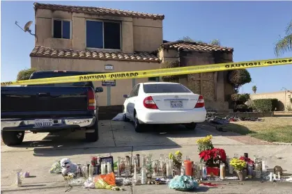  ?? Photograph: Amy Taxin/AP ?? Candles are laid on the sidewalk outside the charred home in Riverside, California on Wednesday. The girl was rescued and is in counseling.