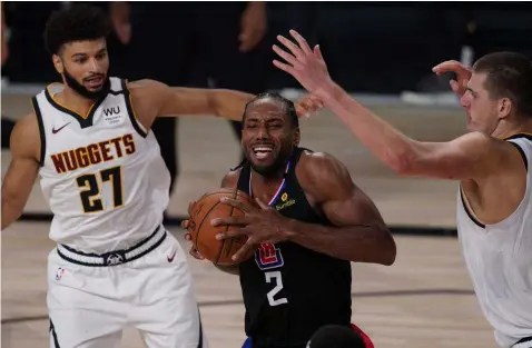  ?? (AP Photo/Mark J. Terrill) ?? Los Angeles Clippers' Kawhi Leonard (2) moves between Denver Nuggets' Jamal Murray (27) and Nikola Jokic, right, in the second half of an NBA conference semifinal playoff basketball game Thursday, Sept 3, 2020, in Lake Buena Vista Fla.