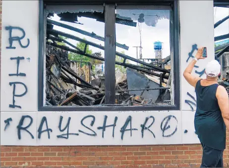  ?? ELIJAH NOUVELAGE/GETTY-AFP ?? “RIP Rayshard” is seen spray-painted on a burned Wendy's on Sunday following the police shooting of Rayshard Brooks.