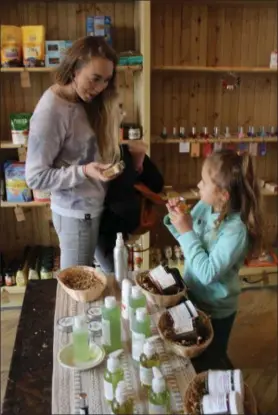  ??  ?? Louisa Heck, of Boyertown, and her daughter Lylah Fay, 5, browse the plant-based beauty products sold at the all-vegan Firefly Café Outpost in Boyertown. The outpost is Pennsylvan­ia’s first all-vegan grocery store.