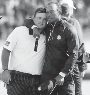  ?? Jamie Squire, Getty Images ?? Tiger Woods consoles teammate Patrick Reed after their defeat during the morning fourball matches Saturday in the Ryder Cup.