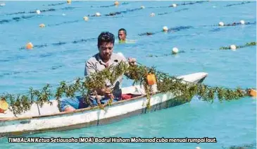 ??  ?? TIMBALAN Ketua Setiausaha (MOA) Badrul Hisham Mohamad cuba menuai rumpai laut.