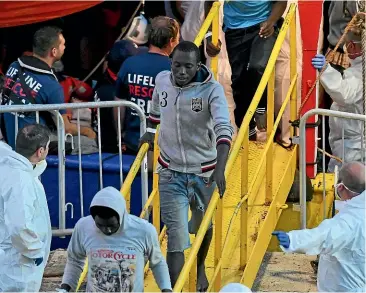  ?? AP ?? Migrants disembark from the ship operated by German aid group Mission Lifeline, carrying 234 migrants, after it docked at Valletta port in Malta on Thursday.