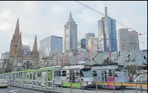  ?? REUTERS ?? Trams pass by Melbourne's city skyline in Australia's secondlarg­est city