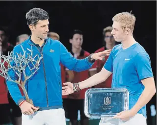  ?? MICHEL EULER THE ASSOCIATED PRESS ?? Novak Djokovic and Denis Shapovalov, right, stand together with their trophies after the final match of the Paris Masters tennis tournament Sunday. Djokovic defeated Shapovalov, 6-3, 6-4.