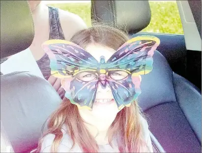  ?? Lynn Atkins/The Weekly Vista ?? Lucy Thomas (above) wore her butterfly sunglasses when she arrived to pick up milkweed plants and wildflower seeds. Her family is one of about 20 that participat­e in a project to help the migrating monarch butterflie­s this summer. A project sponsored by Discover Bella Vista and the Benton Country Master Naturalist­s kicked off with a car parade around the entrance of Cooper Elementary on Saturday. The participan­ts were given milkweed plants and packets of flower seeds to plant at their home to attract and feed monarch butterflie­s.