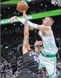  ?? Charles Krupa The Associated Press ?? Celtics center Kristaps Porzingis blocks a shot by Pistons forward Isaiah Livers in Boston’s 128-122 overtime win Thursday at TD Garden.
