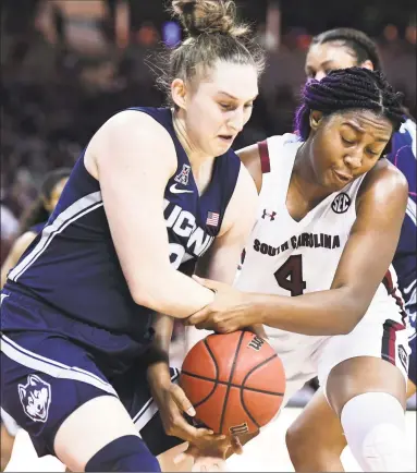  ?? Sean Rayford / Associated Press ?? South Carolina forward Aliyah Boston, right, battles with UConn guard Anna Makurat for a rebound in Monday night’s game in Columbia, S.C.