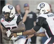  ?? GRAHAM HUGHES/ THE CANADIAN PRESS ?? Ottawa Redblacks quarterbac­k Henry Burris, right, hands off to Chevon Walker during first half CFL football action against the Montreal Alouettes in Montreal on Thursday,