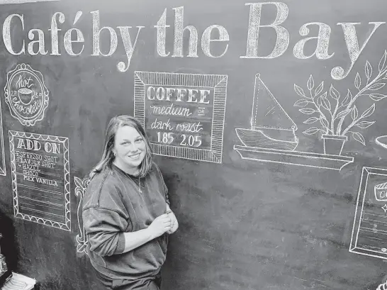  ?? CHRIS CONNORS • CAPE BRETON POST ?? Chalkboard artist Kirstie Power works on the new menu for Café By the Bay. The coffee shop recently opened on Charlotte Street in Sydney.