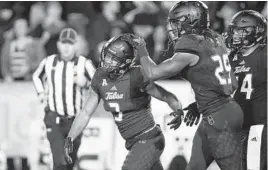  ?? SUE OGROCKI/ASSOCIATED PRESS ?? Tulsa running back Shamari Brooks, left, celebrates with teammate Justin Hobbs during a game earlier this season against South Florida.