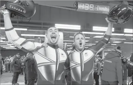  ?? THE CANADIAN PRESS/JONATHAN HAYWARD ?? Canada’s Alexander Kopacz, left, and Driver Justin Kripps celebrate their tied gold medal with Germany after the two-man bobsled final during the Pyeongchan­g 2018 Winter Olympic Games in South Korea on Monday.