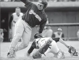  ??  ?? MICHAEL GALLACHER/ MISSOULIAN­David Denson of the Helena Brewers is tagged out at home by Missoula Osprey catcher Matt Jones as he attempts to score from third on an errant pitch in June.