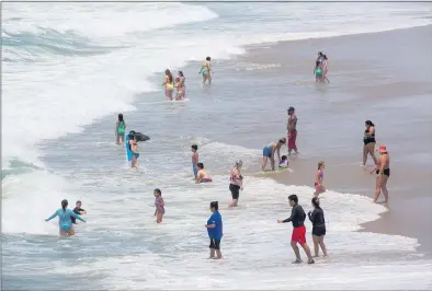  ?? PHOTO BY CHUCK BENNETT ?? People without masks take to the water in Hermosa Beach on Tuesday after California officials lifted nearly all COVID-19 restrictio­ns.