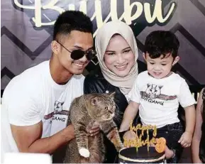  ??  ?? Popular British shorthair cat Bujibu Chempel and its owners, celebrity couple Hairul Azreen (left) and Hanis Zalikha (centre), during its birthday bash at SPCA Malaysia on Monday.