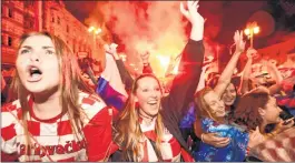  ??  ?? Croatian supporters rejoice after a goal is scored as they watch on a giant screen in Zagreb.