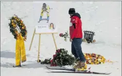  ?? FABRICE COFFRINI/AFP/GETTY Images ?? A member of the Swiss ski team lays a flower during a ceremony Sunday marking the death of Canada’s Nick Zoricic at a World Cup event Saturday.