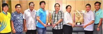  ??  ?? Temenggong Lau (third right) hands over the secondary school category challenge cup to Sie Yong, while Kapitan Lau (fourth right) hands over the primary school category challenge cup to Ching Diak, as others look on.