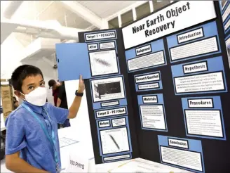  ?? ?? Junior Division overall winner and published astronomer Asher Tokuoka, 13, explains the methodolog­y he used for his project titled “Near Earth Objects Recovery.” Tokuoka is a sixth grader at Iao Intermedia­te School.