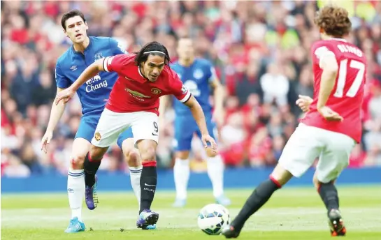  ??  ?? Radamel Falcao of Manchester is tackled by an Everton defender during the Barclays English Premier League match, while his teammate Blind waits for a slip.