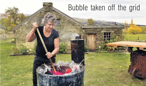  ?? PHOTO: STEPHEN JAQUIERY ?? Living in the 1800s . . . Lou Farrand washes her clothing in a copper boiler at her historic cottage near Roxburgh. She has no running water and no power but is thriving.