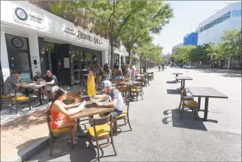  ?? Matthew Brown / Hearst Connecticu­t Media ?? Diners sit at tables outside Bedford Hall Craft Kitchen and Bar on May 30 in Stamford. “A vaccine may not show up until the second quarter of 2021,” Director of Economic Developmen­t Thomas Madden said. “The question is how we keep people in business until then.”