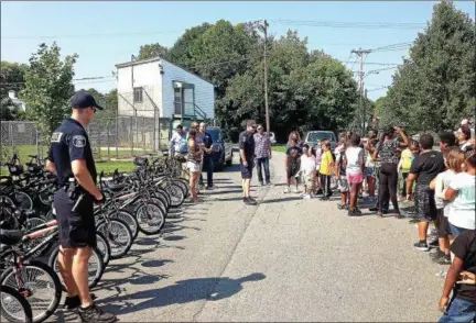  ?? ARIÉL ZANGLA — DAILY FREEMAN ?? Kingston City police officers Ryan Shuman, center, and Bryan Aitken discuss bicycle safety on Thursday as 50 bikes were donated to children in the Boys & Girls Clubs in Kingston and Saugerties by the CAN’d Aid Foundation and Craft New York.