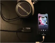  ??  ?? Periodic Audio’s Nickel amplifier is about the size of a 9-volt battery, shown here with an iphone XS and Beyerdynam­ic Amiron Home headphones.