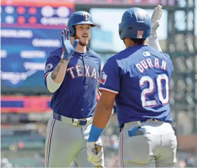 ?? LON HORWEDEL/USA TODAY SPORTS ?? The Texas Rangers’ Jonah Heim, left, celebrates with Ezequiel Duran after hitting a home run against the Tigers in the second inning of Thursday’s game at Comerica Park in Detroit.
