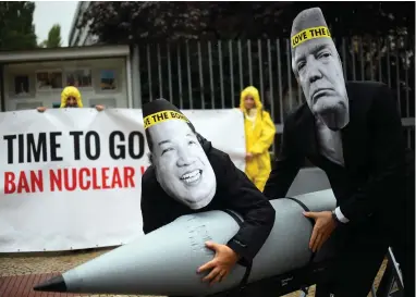  ?? PICTURE: AP ?? NO NUKES: Internatio­nal Campaign to Abolish Nuclear Weapons activists protest against North Korea and US conflict with masks of Kim Jong-Un and president Donald Trump at the US embassy in Germany.