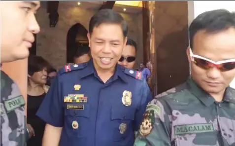  ?? CAMILLE PATERES ?? Celebrated police officer Chief Inspector Jovie Espenido is escorted by his men while attending a church service in Cebu City yesterday.