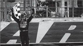  ?? JEFF SINER/TRIBUNE NEWS SERVICE ?? NASCAR driver Kyle Busch carries the checkered flag after winning the NASCAR Monster Energy All-Star Race on May 20 in Concord, N.C.