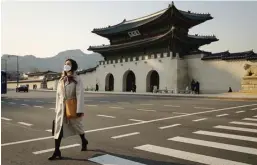  ?? ED JONES/AFP ?? NYARIS KOSONG MELOMPONG: Seorang turis melintasi jalan di depan Istana Gyeongbokg­ung di Seoul, Korsel, kemarin. Foto kiri, Lapangan Santo Petrus di Vatikan yang tak lagi dipadati pengunjung.