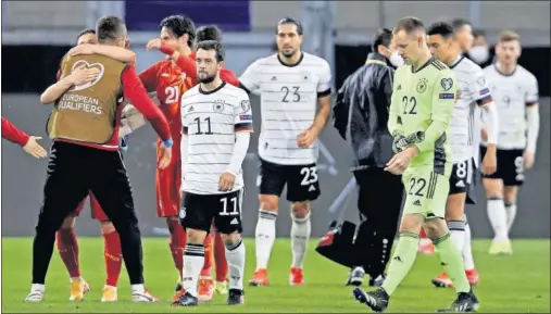  ??  ?? Los jugadores de la selección alemana, abatidos tras la derrota con Macedonia del Norte.