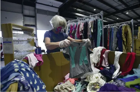  ?? Jeremy Papasso, Daily Camera ?? A Precious Child volunteer Jill Lewis sorts through donated girls clothes on Thursday at the nonprofit’s location in Broomfield.
