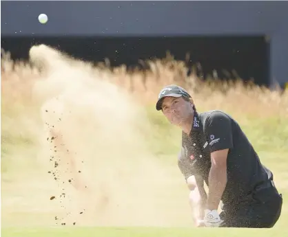  ?? GETTY IMAGES ?? Kevin Kisner plays out of a greenside bunker on the 18th hole during the first round of the British Open at Carnoustie.