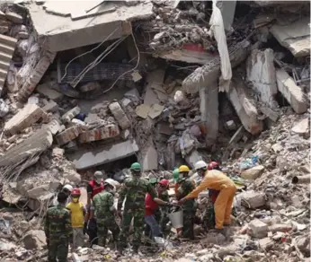  ?? WONG MAYE-E/THE CANADIAN PRESS FILE PHOTO ?? Workers try to release two bodies trapped in the rubble of the collapsed factory in Bangladesh on April 30, 2013.