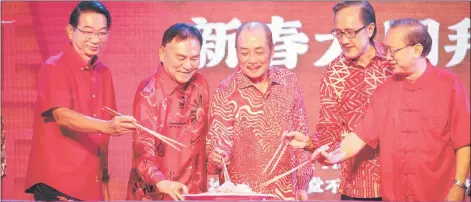  ?? ?? Chin (second left), Hajiji (centre), Masidi (second right) and others tossing the Yee Sang at the Chinese New Year celebratio­n.