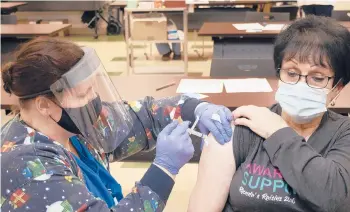  ?? MATT JONES/THE DAILY INDEPENDEN­T ?? Leslie Boardman, a nurse at the Greenup County Health Department, vaccinates Lois Cool on Tuesday in Greenup, Kentucky. Cool received the vaccine as part of the rollout for those 70 and older in the state.